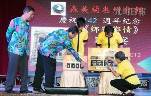 森州惠州会馆142周年会庆联欢宴上，黄俊棠（左起）与萧富文一同摇出8195这个幸运字，没想到这一组万字在9月2日开出首奖，让280名赴宴者有奖同享，乐不可支。（马来西亚光明日报）